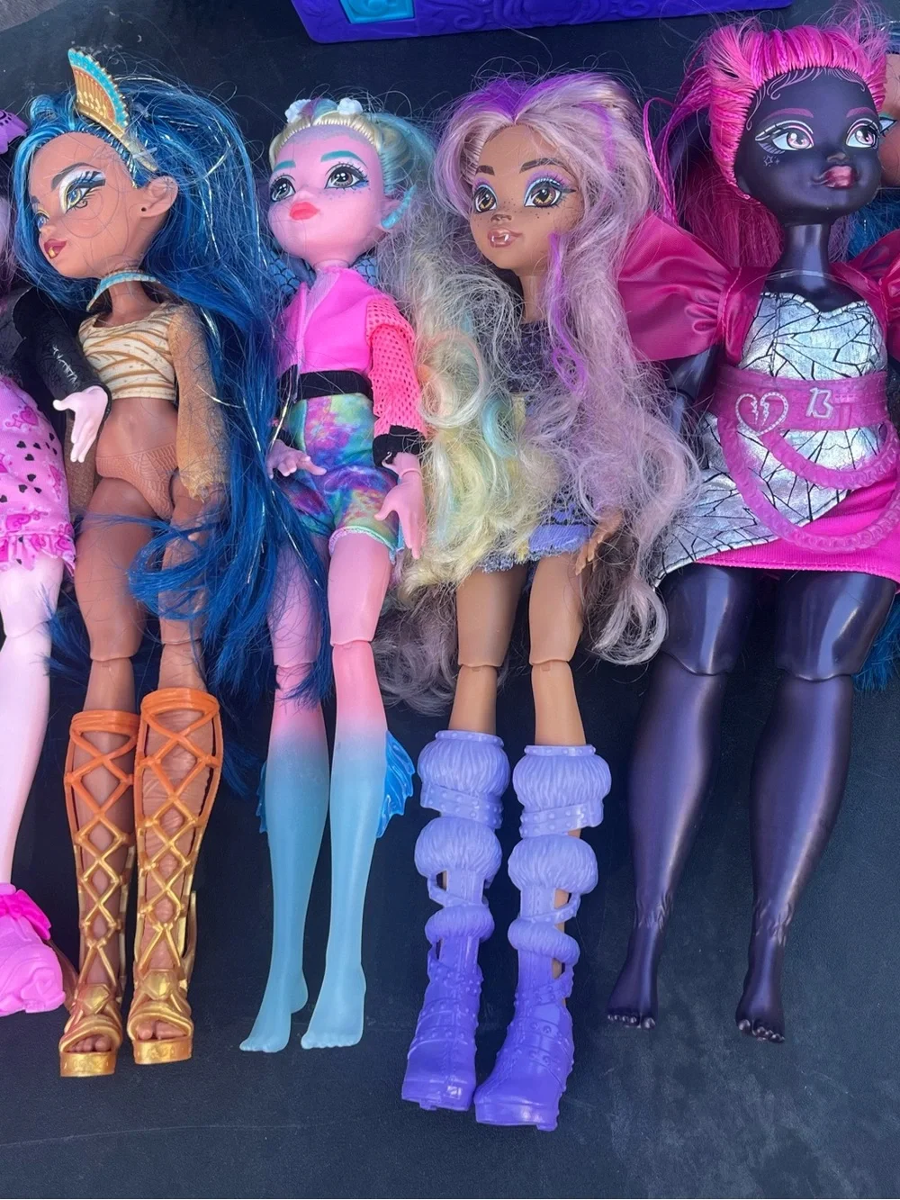 monster high dolls set with purple, teal, pink and blue carrier